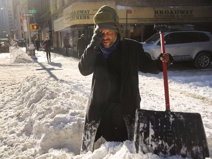 Diego Ramos, một người vô gia cư hiện sống dưới các giàn giáo ở các công trình xây dựng, tạm dừng việc cào tuyết do đã khá thấm mệt.
