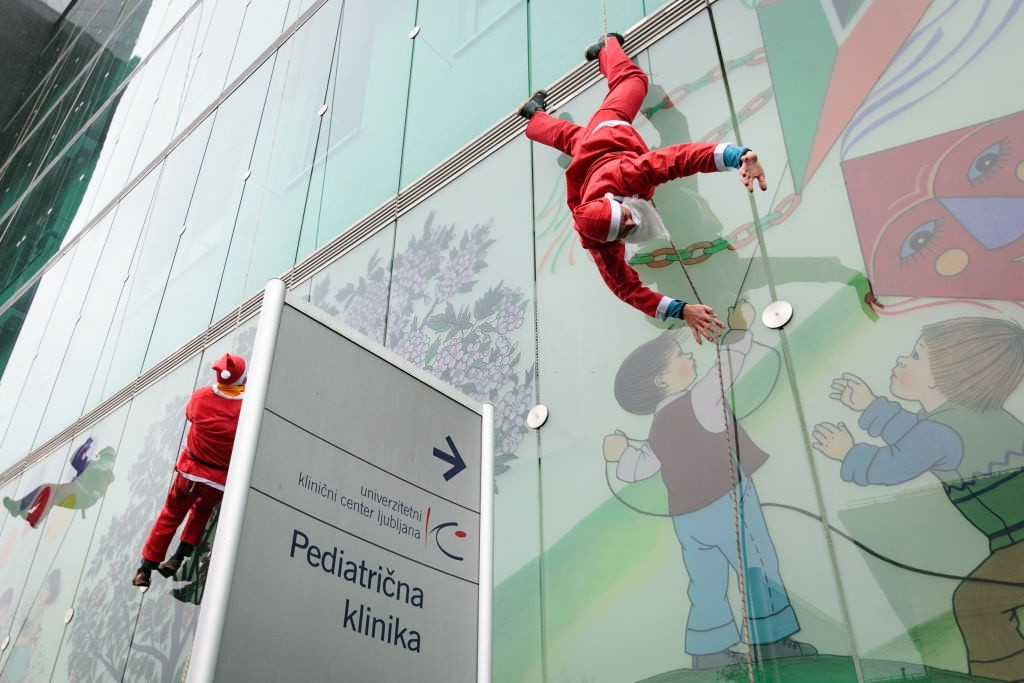 Đại dịch Covid-19 khiến việc tiếp xúc giữa người lạ trở nên nguy hiểm hơn, đặc biệt đối với trẻ em. Thông thường, vào dịp Giáng sinh, các bệnh viện nhi thường mời ông già Noel tới để chung vui cùng trẻ nhỏ. Tuy nhiên, do đại dịch, các bệnh nhân nhí ở Ljubljana, Slovenia đã được gặp ông già Noel phiên bản leo tường. Ảnh: Ales Beno.