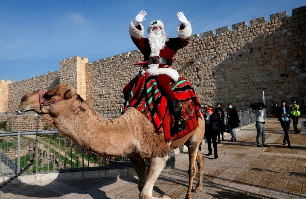 Issa Kassissieh, một học giả nổi tiếng ở Jerusalem (Israel), trong trang phục ông già Noel, cưỡi lạc đà. Ảnh: AFP.