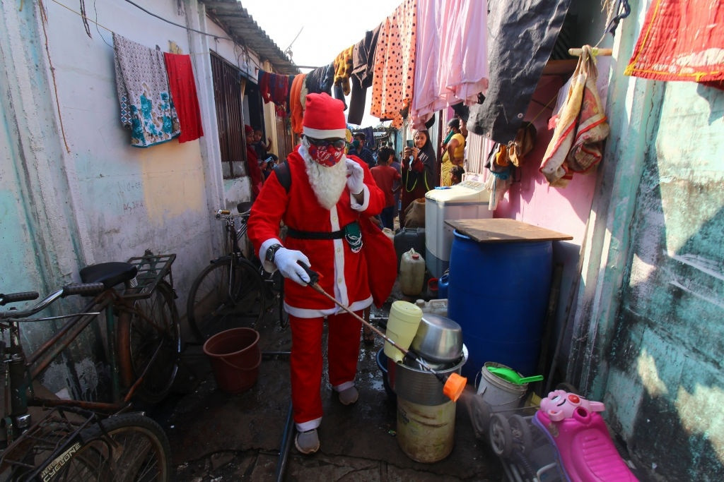 Ông già Noel này đang làm nhiệm vụ khử khuẩn để ngăn chặn sự lây lan của đại dịch Covid-19 tại một khu ổ chuột ở Mumbai, Ấn Độ. Trong 23/12, thành phố Mumbai ghi nhận 745 ca dương tính mới, nâng tổng số ca nhiễm lên 2.88.561 trường hợp. Tổng số người chết là 11.033. Riêng hôm 23/12, số ca tử vong được ghi nhận lên tới 14 người. Ảnh: Himanshu Bhatt.