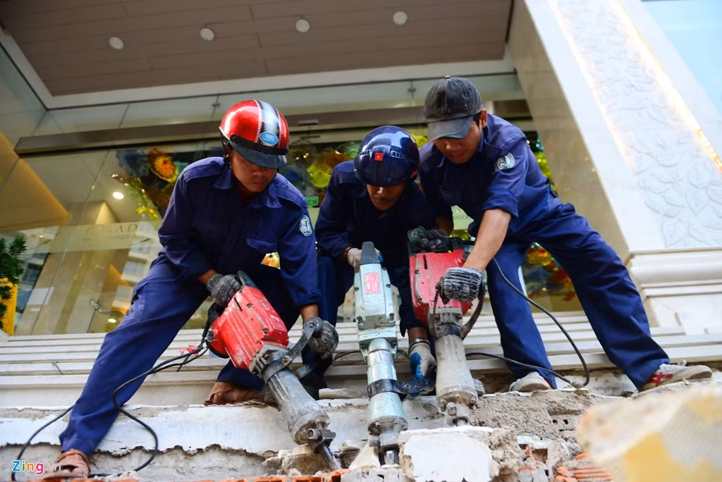 Lực lượng chức năng nhanh chóng đập bỏ các bậc tam cấp của khách sạn 3 sao lấn ra vỉa hè.