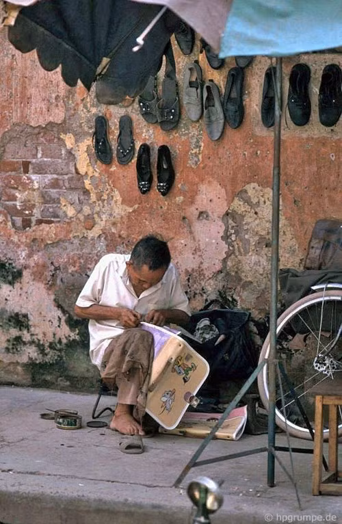 Tiệm sửa giày dép, cặp học sinh trên vỉa hè.