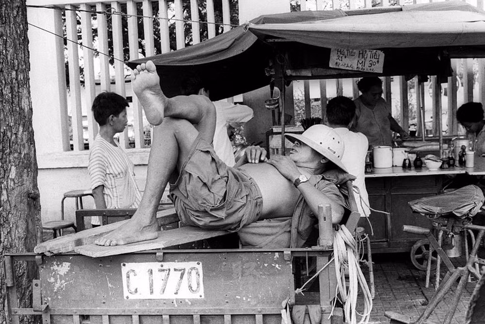 Giấc ngủ của người lái xe ba gác trên vỉa hè. Ảnh: Michael Burr