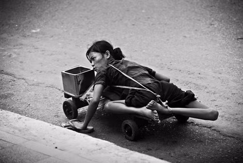 Một người tàn tật đi ăn xin dọc theo vỉa hè Sài Gòn, 1980. Ảnh: Philip Jones Griffiths.