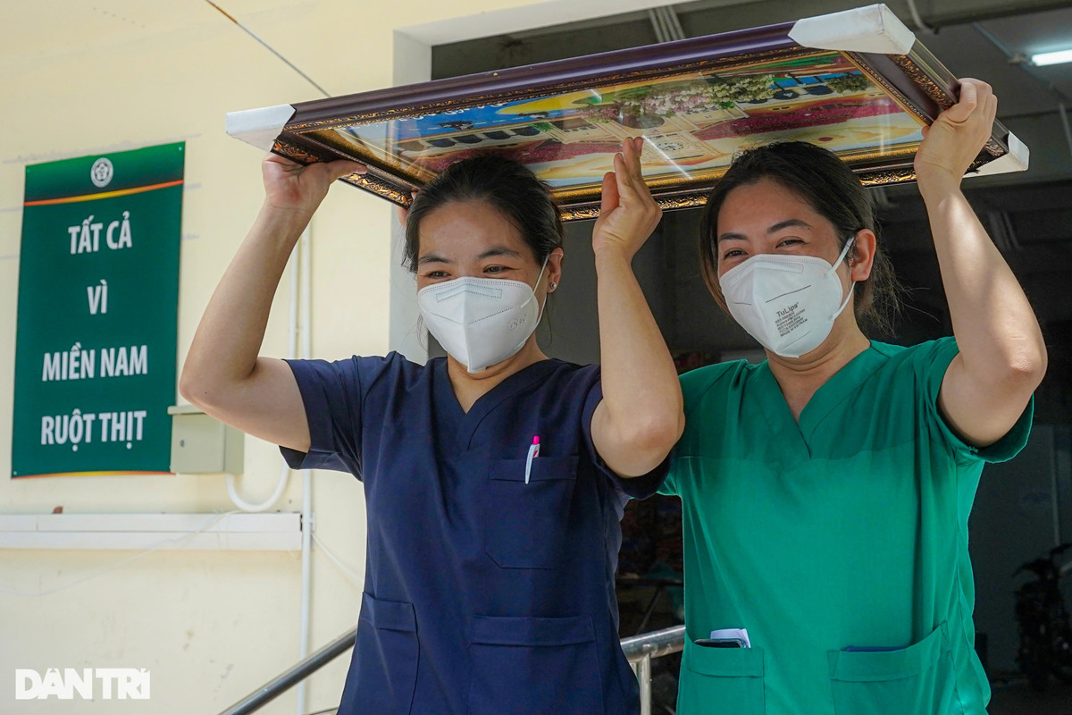 Giữa trưa, trời nắng gắt, hai nữ điều dưỡng che trên đầu món quà các đồng nghiệp bệnh viện Quận 7 gửi tặng rời bệnh viện dã chiến số 16 về khách sạn chuẩn bị đồ ra sân bay, kết thúc nhiệm vụ chi viện tại TP HCM.