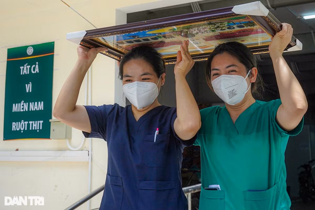 Giữa trưa, trời nắng gắt, hai nữ điều dưỡng che trên đầu món quà các đồng nghiệp bệnh viện Quận 7 gửi tặng rời bệnh viện dã chiến số 16 về khách sạn chuẩn bị đồ ra sân bay, kết thúc nhiệm vụ chi viện tại TP HCM.