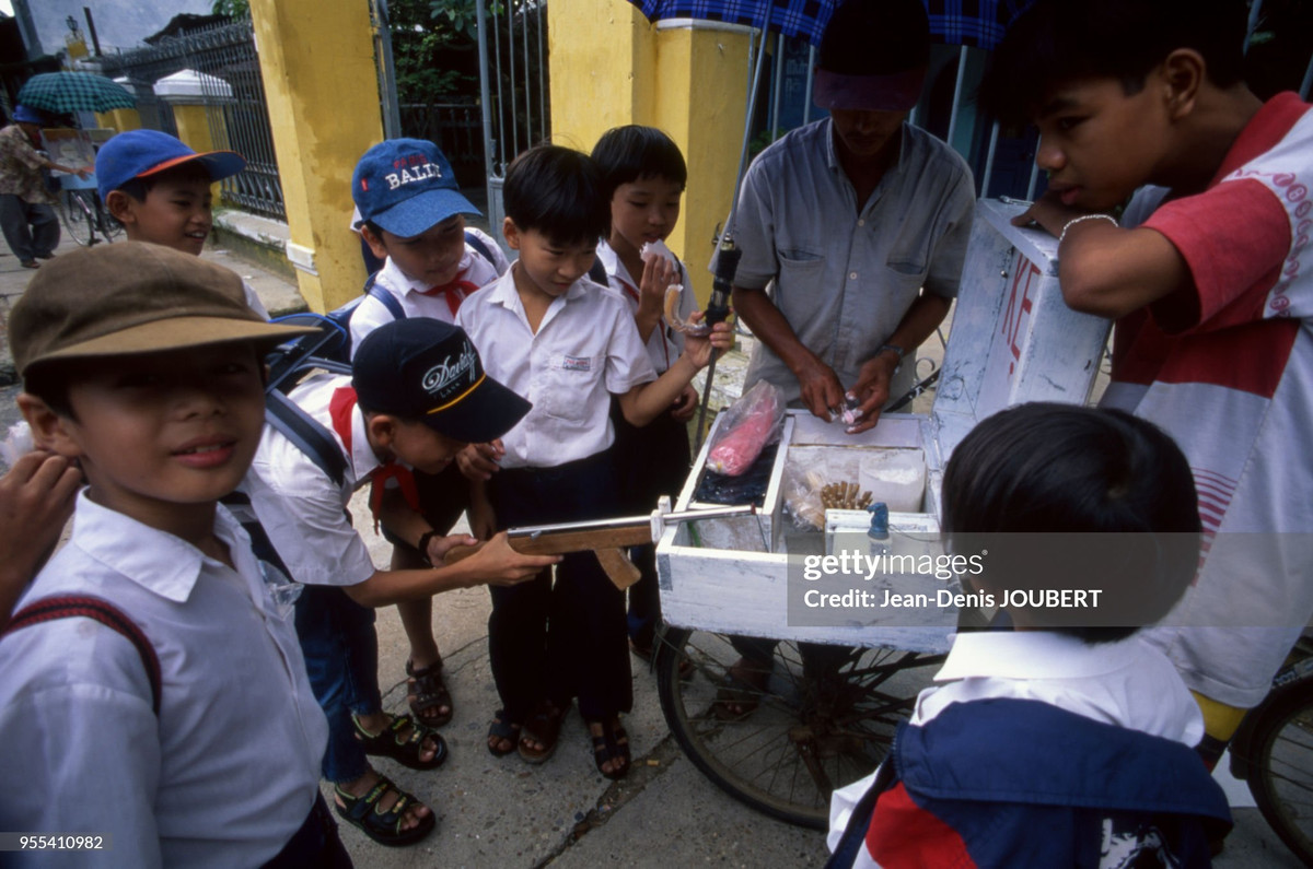 Các cậu bé học trò chơi trò bắn súng thưởng kẹo sau giờ tan trường.