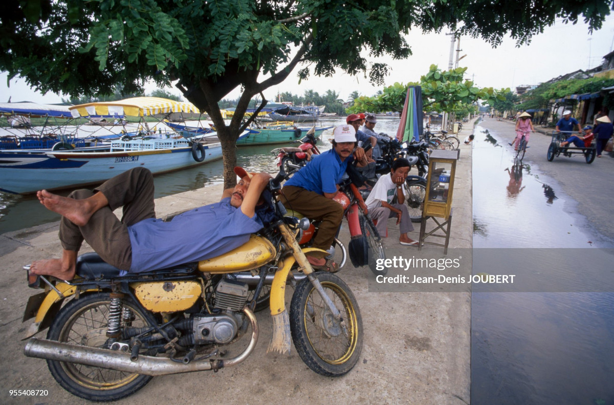 Tài xế xe ôm chờ khách bên bờ sông Thu Bồn.