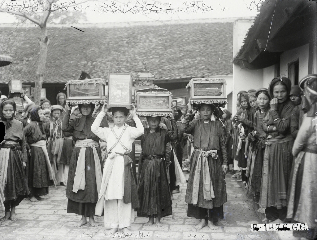 Nhóm phụ nữ vận chuyển đồ thờ tự đi theo đám rước.