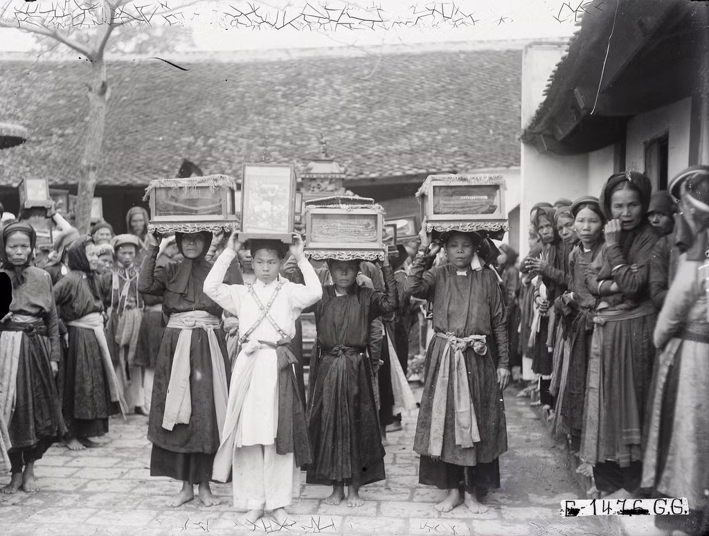 Nhóm phụ nữ vận chuyển đồ thờ tự đi theo đám rước.