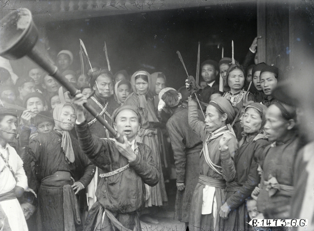 Một người dùng loa kêu gọi đám đông nhường lối cho đám rước đi qua.