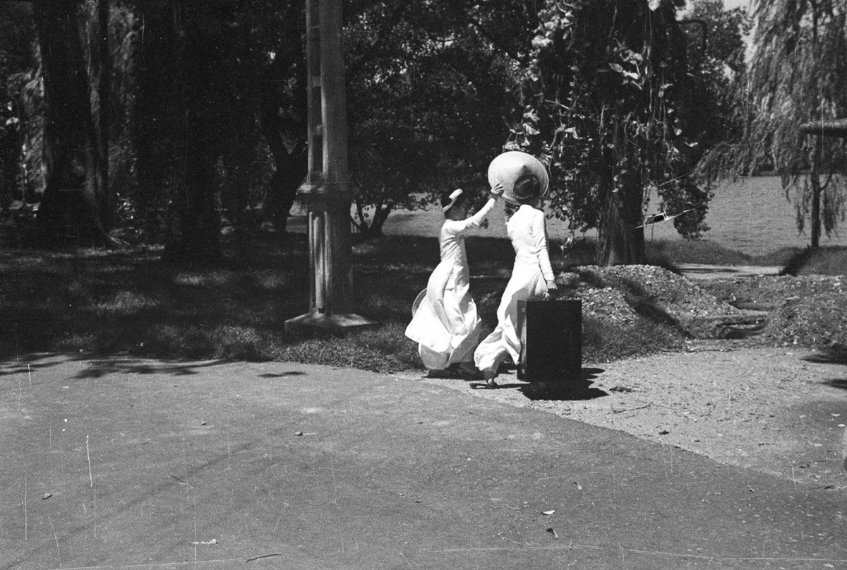 Hai thiếu nữ đi qua bờ hồ.