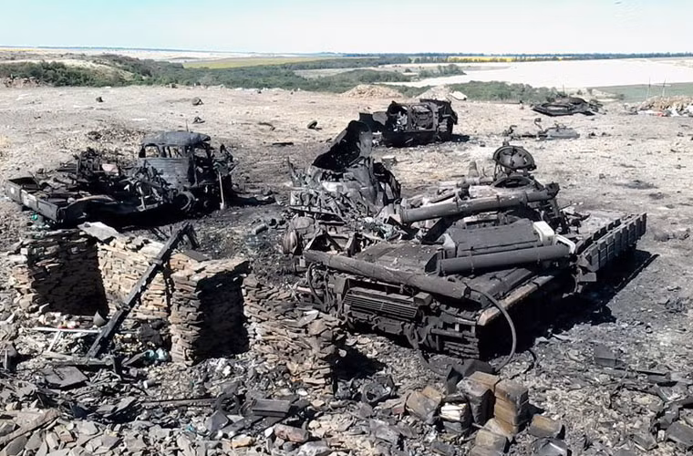 Một chiếc xe tăng T-64BV bị bắn cháy đen nằm cạnh xác xe vận tải, xe chiến đấu BMP (nằm cách xa), ảnh chụp hôm 24/7/2014. T-64BV trang bị giáp phản ứng nổ Kontakt 1 nhưng không giúp nó thoát khỏi số phận nghiệt ngã.