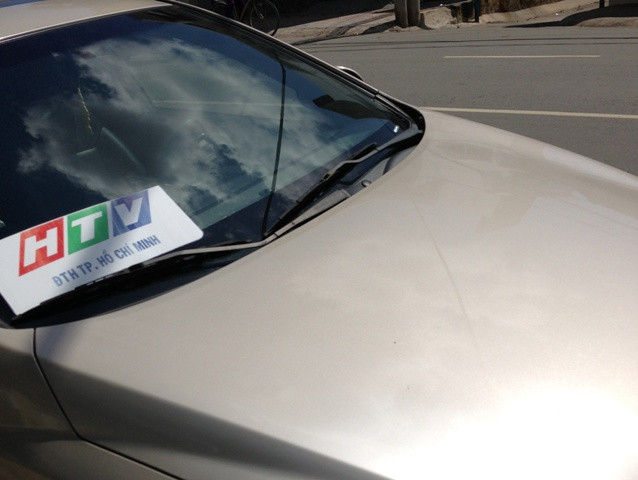 Một ôtô với logo Đài truyền hình TP.HCM dán trước kính xe. Với logo này ai cũng có thể làm được dù không liên quan gì đến đài HTV. Tuy nhiên nó cũng "có giá trị" khi lưu thông trên đường nếu lỡ vi phạm giao thông cũng dễ được thông cảm.