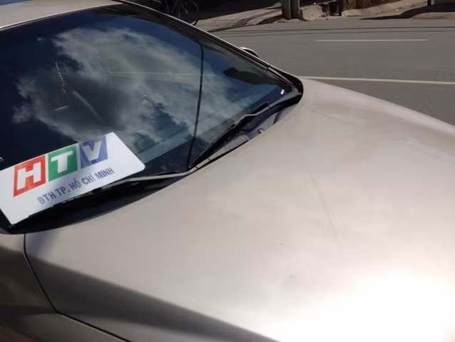 Một ôtô với logo Đài truyền hình TP.HCM dán trước kính xe. Với logo này ai cũng có thể làm được dù không liên quan gì đến đài HTV. Tuy nhiên nó cũng "có giá trị" khi lưu thông trên đường nếu lỡ vi phạm giao thông cũng dễ được thông cảm.