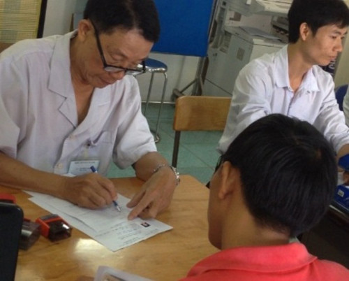 Vị bác sĩ đeo bảng tên Vũ Hữu Loan, bệnh viện GTVT TPHCM thực hiện khám sức khỏe cho những người có nhu cầu về thi, cấp, đổi GPLX tại điểm Linh Xuân, Thủ Đức (ảnh cắt từ clip).