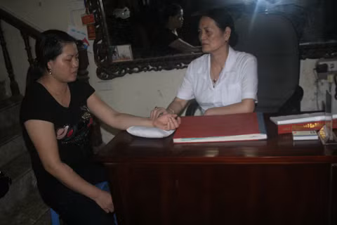 Bà Lâm đang bắt mạch cho chị Văn. Bà Lâm đang bắt mạch cho chị Văn.