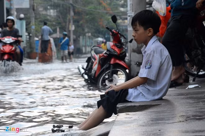 Chiều 26/11, sau cơn mưa lớn, hai con hẻm này tiếp tục bị ngập nước đến nửa bánh xe máy. Đây là ngày thứ 5 liên tiếp phụ huynh và học sinh phải đánh vật với "con sông" bất đắc dĩ này.