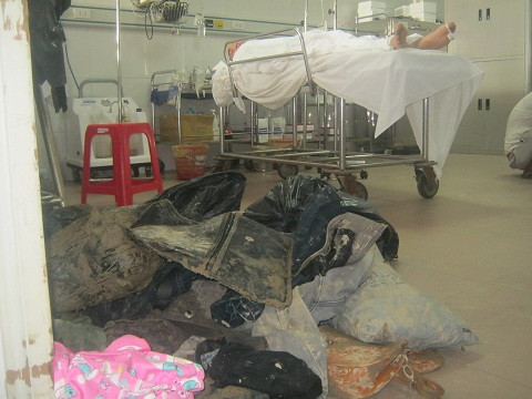 Trong phòng cấp cứu nạn nhân nằm bất động, trước cửa phòng những bộ quần áo dính đầy bùn đất.