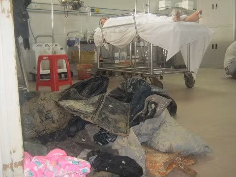 Trong phòng cấp cứu nạn nhân nằm bất động, trước cửa phòng những bộ quần áo dính đầy bùn đất.
