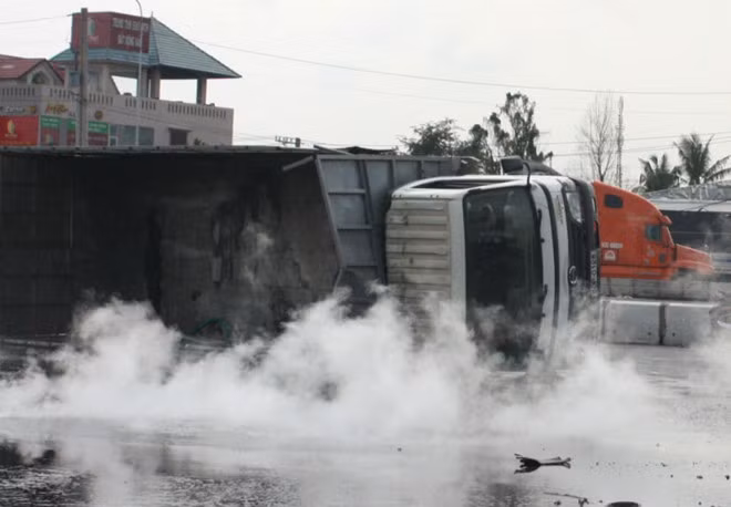 Khi ôm cua vòng xoay đường Bùi Văn Hòa - Võ Nguyên Giáp thì xe bất ngờ lật nhào khiến lượng lớn axít trong thùng đổ ra đường.