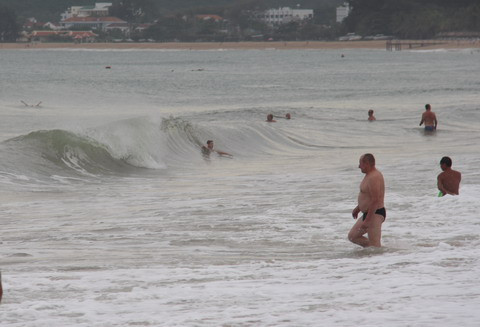 Tại vùng tâm bão, bãi biển Nha Trang (Khánh Hòa), sáng nay trời u ám, nhiều mây. Mặc dù sóng biển khá lớn nhưng vẫn có nhiều khách du lịch vui đùa cưỡi sóng.