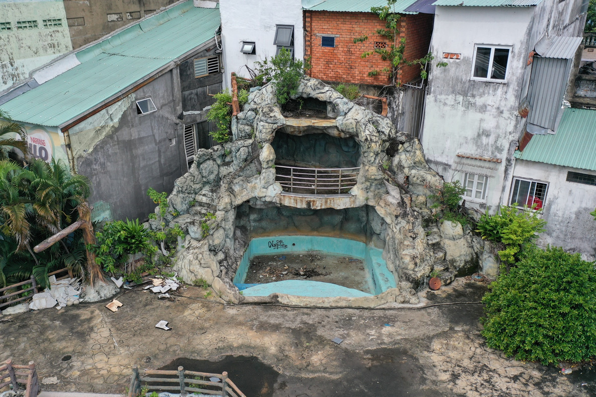 Một hồ bơi với hệ thống sân khấu nổi, dây đu, cầu phao... giờ đây trống trơn mọc đầy rêu xanh.