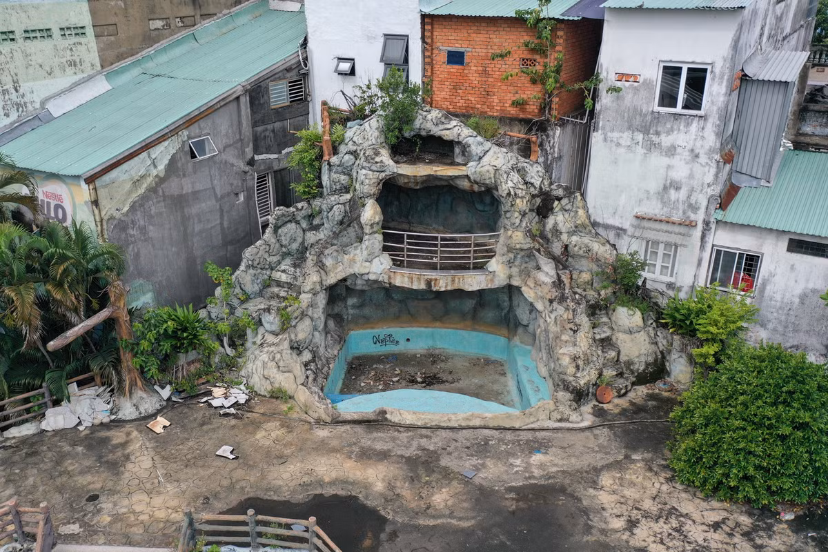 Một hồ bơi với hệ thống sân khấu nổi, dây đu, cầu phao... giờ đây trống trơn mọc đầy rêu xanh.