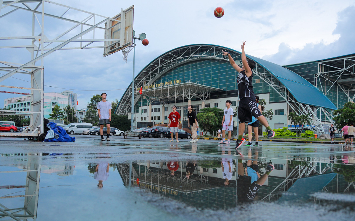 Dù mưa đã tạnh khá lâu nhưng sân tập vẫn đọng nước gây trơn trượt. Nhóm bạn của Khải (áo đen) cho biết phải di chuyển khá xa từ các quận, huyện vùng ven TP HCM như Bình Tân, Bình Chánh thậm chí là Bình Dương vì khu họ sinh sống rất ít các sân chơi thể thao rộng rãi như nhà thi đấu Phú Thọ. "Vào cuối tuần nhóm mình thường xuyên đến đây để chơi bóng rổ vì sân tập rộng rãi và giá cả cũng không quá cao. Tuy nhiên nhóm mình chỉ mướn được nửa sân tập với giá 60.000 đồng một giờ do lượng người chơi đổ về đây quá đông", Khải nói.