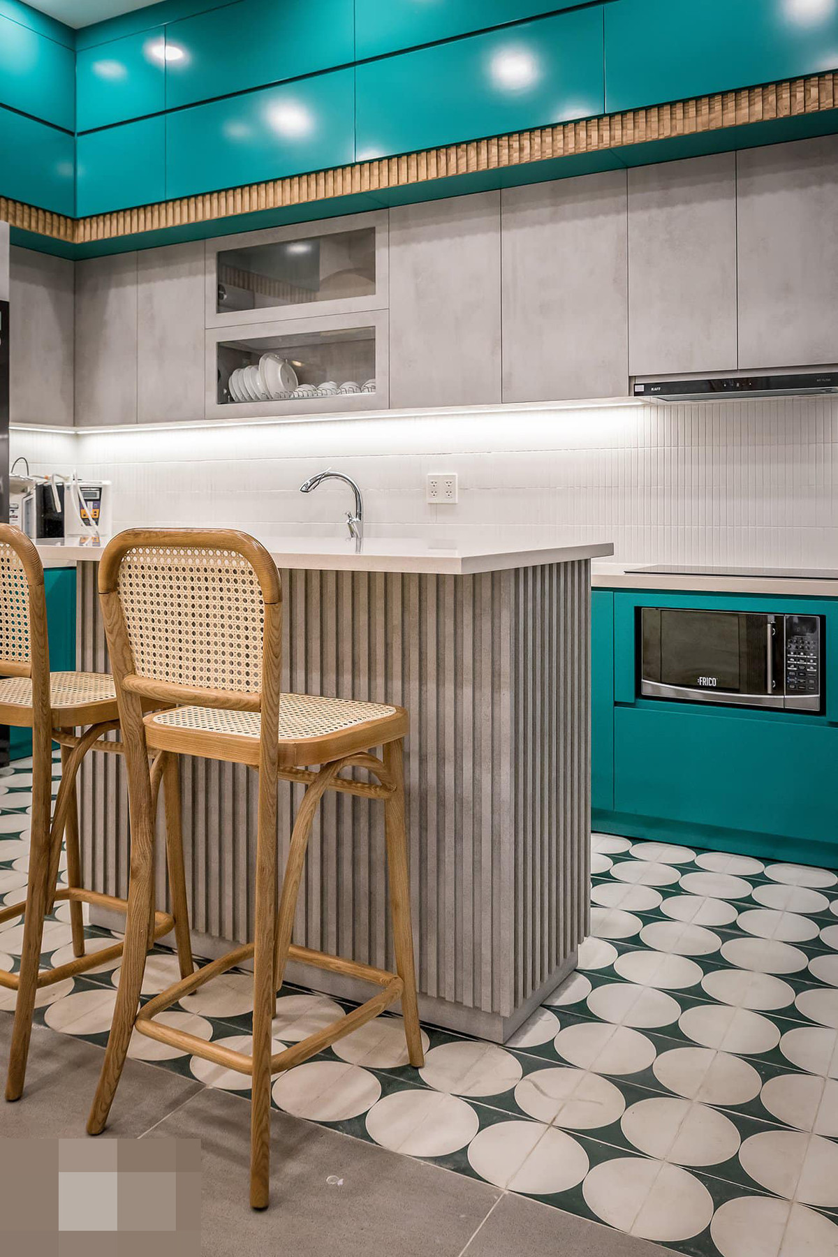 Bàn đảo và bàn ăn thiết kế tương đồng với ghế tựa phối mây mắt cáo, mặt bàn ốp đá nhân tạo.