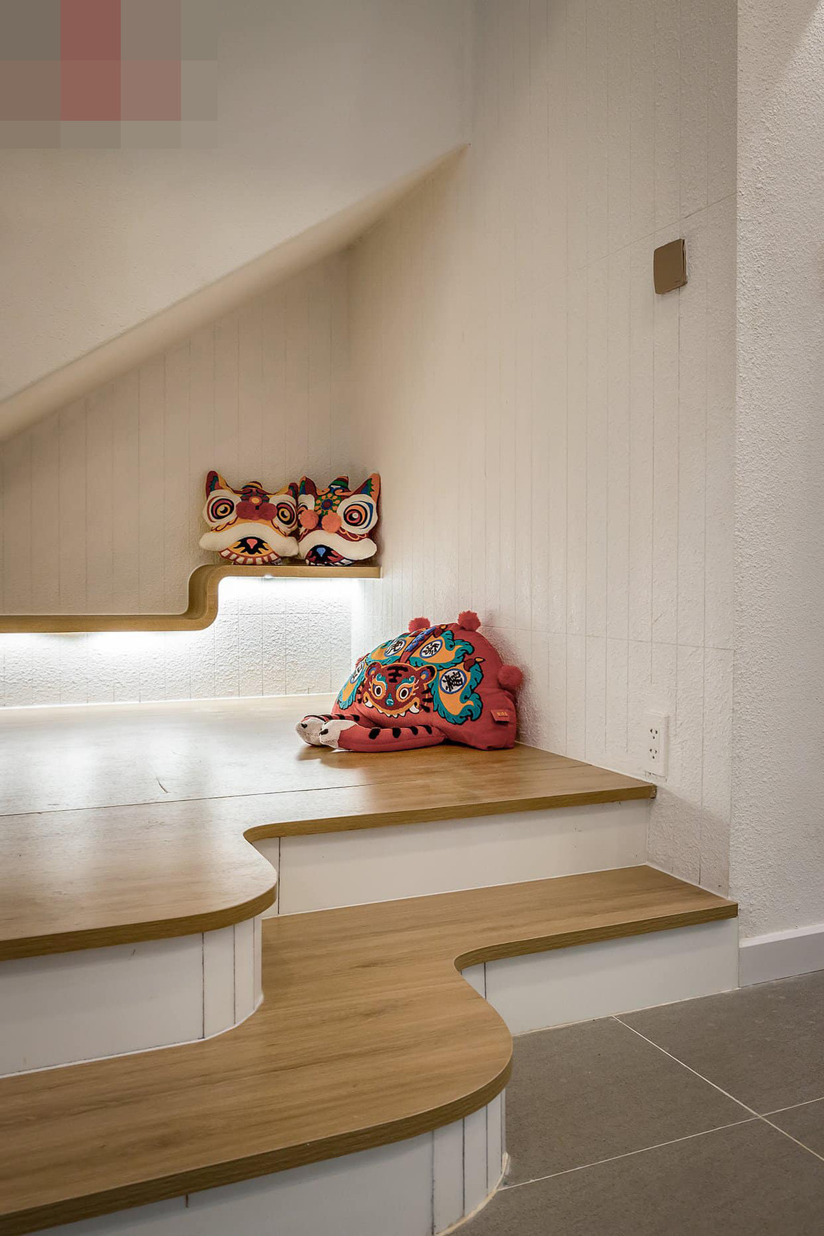 Cầu thang ốp gỗ công nghiệp, mát rượi mà không bị trơn. Gầm cầu thang thành góc trang trí đẹp mắt.