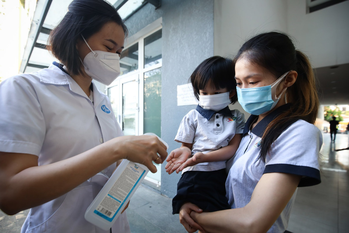 Nhà trường sắp xếp cán bộ y tế đo nhiệt độ, rửa tay, phân luồng, đưa trẻ vào lớp học.