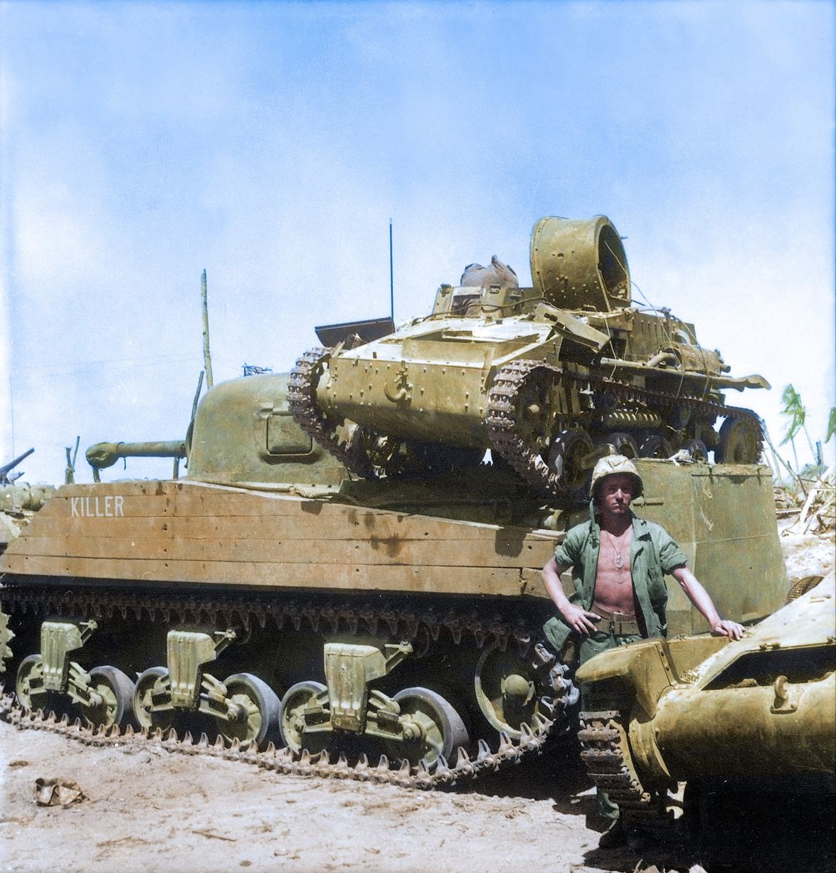 Một binh sĩ Mỹ đứng bên cạnh xe tăng hạng trung M4 Sherman trên đảo san hô Kwajalein. Ảnh: The Sun.