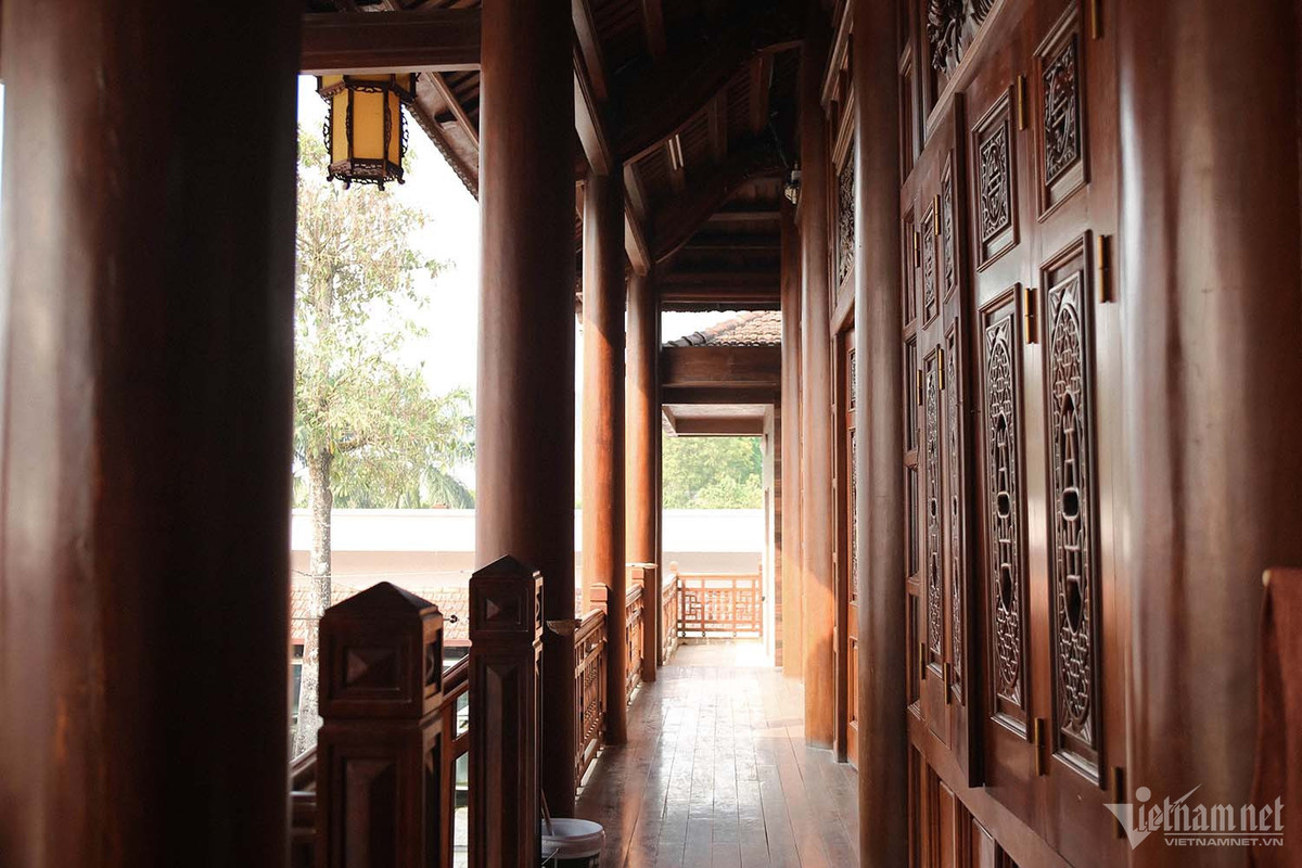 Theo lối kiến trúc của đồng bào dân tộc Thái, nhà sàn gỗ lim gồm có 7 gian khách, 3 gian mái mỗi gian rộng 3,8m cùng 25 bức chạm trổ trang trí nhiều hoa văn tinh xảo trên khung cửa sổ. Cột nhà được dựng từ gỗ lim nguyên khối hơn 900 tuổi. Ảnh: Nhị Tiến