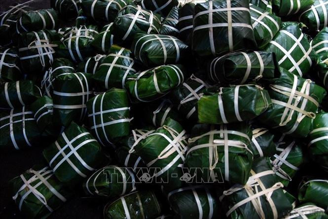 Những chiếc bánh vuông vức, đẹp, chắc nổi bật màu trắng của lạt giang để khi luộc đảm bảo không bị méo, đây là một trong những tiêu chí hình thành thẩm mỹ cho một chiếc bánh chưng Tết đạt tiêu chuẩn. Ảnh: TTXVN