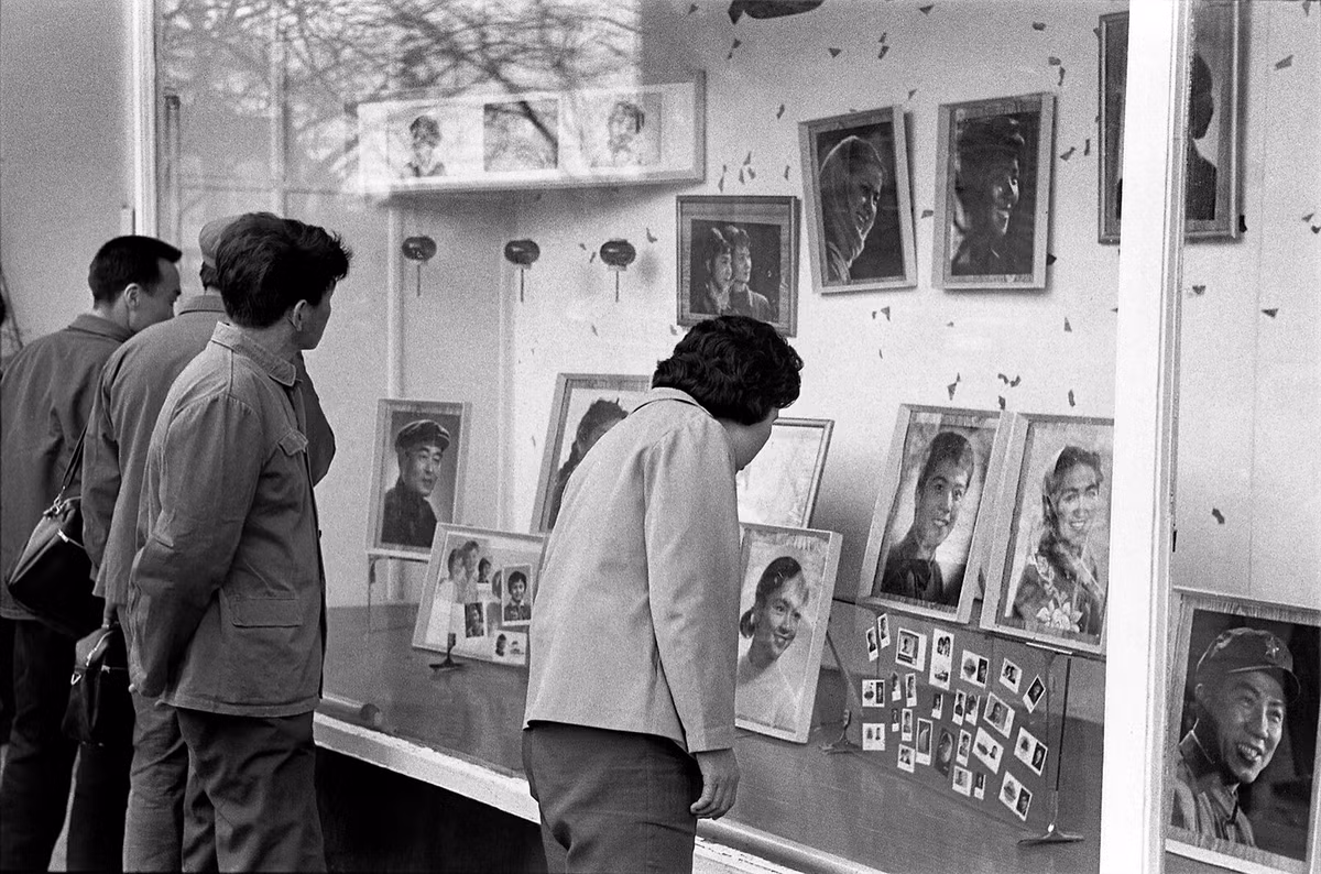 Người qua đường dừng chân bên tủ kính của một hiệu ảnh.