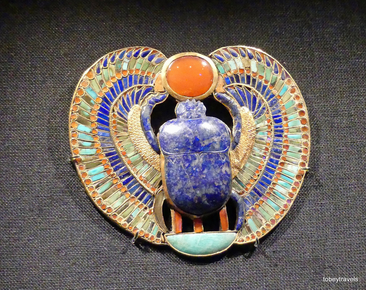 Tầm đeo ngực bằng vàng và đá quý, ở giữa có hình bọ hung - hiện thân của thần mặt trởi Khepri - bằng ngọc lưu ly. Người Ai Cập cố đại thường đặt hình bọ hung trên các xác ướp để bảo vệ người đã khuất trước thế lực ma quỷ.