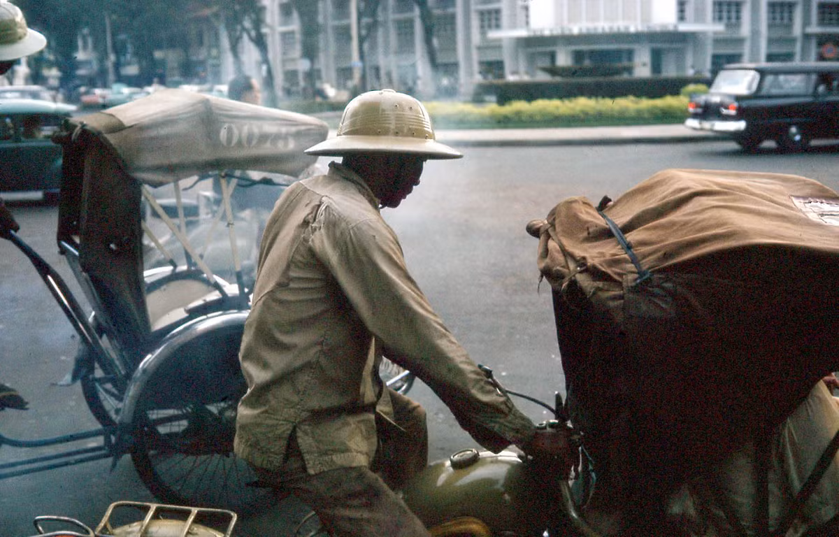 Những chiếc xích lô đi qua ngã tư Lê Lợi - Nguyễn Huệ.