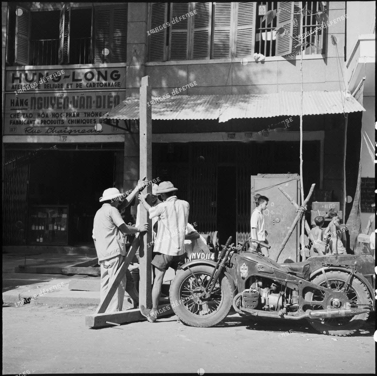 Những người đàn ông lắp đặt một công trình bằng gỗ trên vỉa hè đường Chaigneau, nay là đường Tôn Thất Đạm.