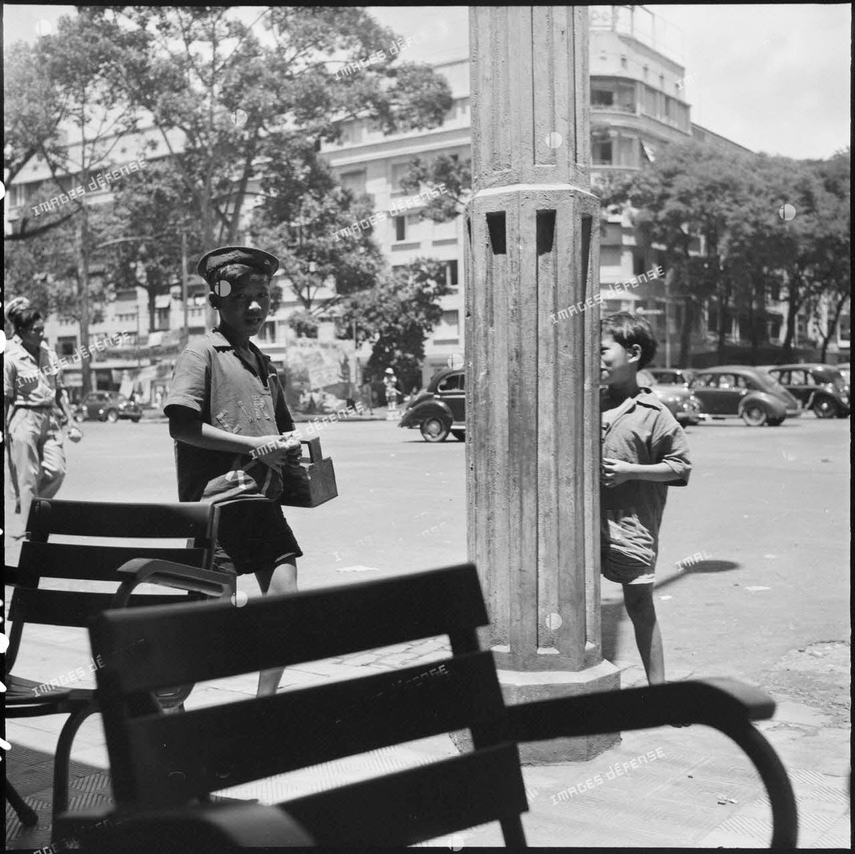 Cậu bé đánh giày thơ thẩn bên quán cà phê vỉa hè.