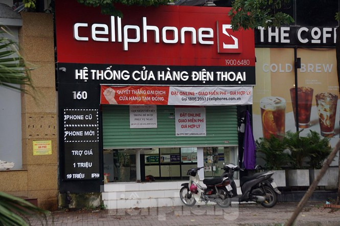 ##s###Trong khi đó, nhiều cửa hàng bán thiết bị điện tử, điện thoại hé cửa. Nhân viên sửa soạn cửa hàng bên trong chờ được hoạt động.