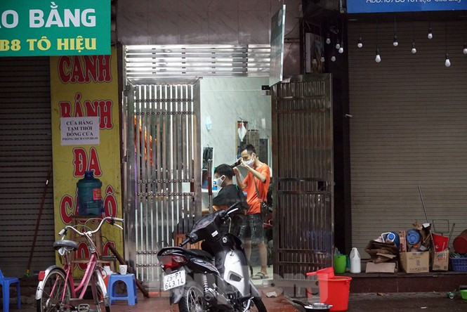 ##s###Một chủ tiệm cắt tóc trên phố Tô Hiệu mở cửa phục vụ khách sáng 22/4.