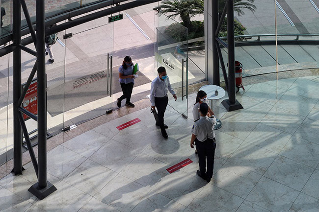 Lực lượng an ninh luôn túc trực để đo thân nhiệt cho người dân trước khi vào cửa và liên tục nhắc nhở mọi người đeo khẩu trang đúng quy định.