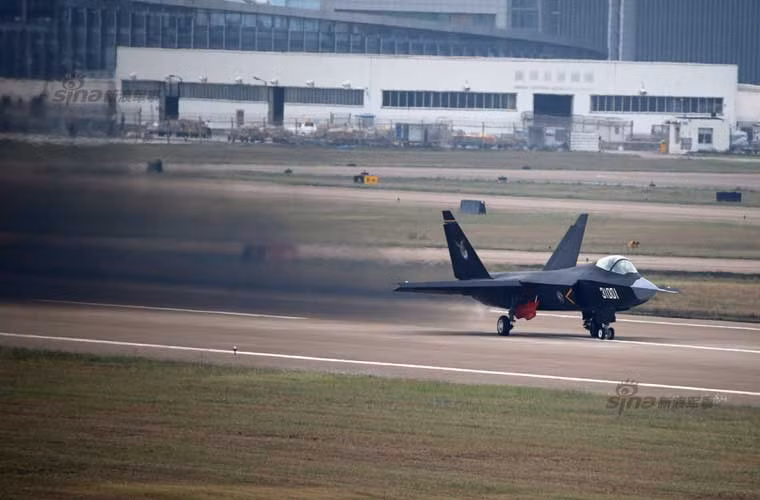 Trang mạng Sina đăng tải một loạt các bức ảnh rõ nét về chuyến bay huấn luyện của tiêm kích tàng hình J-31 để chuẩn bị cho cuộc bay chính thức tại triển lãm hàng không Chu Hải (từ 11-16/11) trước con mắt của hàng nghìn khách tham quan và các quan chức quân sự quốc tế. Đáng thất vọng là lần ra mắt này không được như ý khi động cơ của J-31 có vẻ như không ổn. Trong ảnh, 2 động cơ phản lực trên J-31 xả khói đen mù mịt khi chạy đà cất cánh.