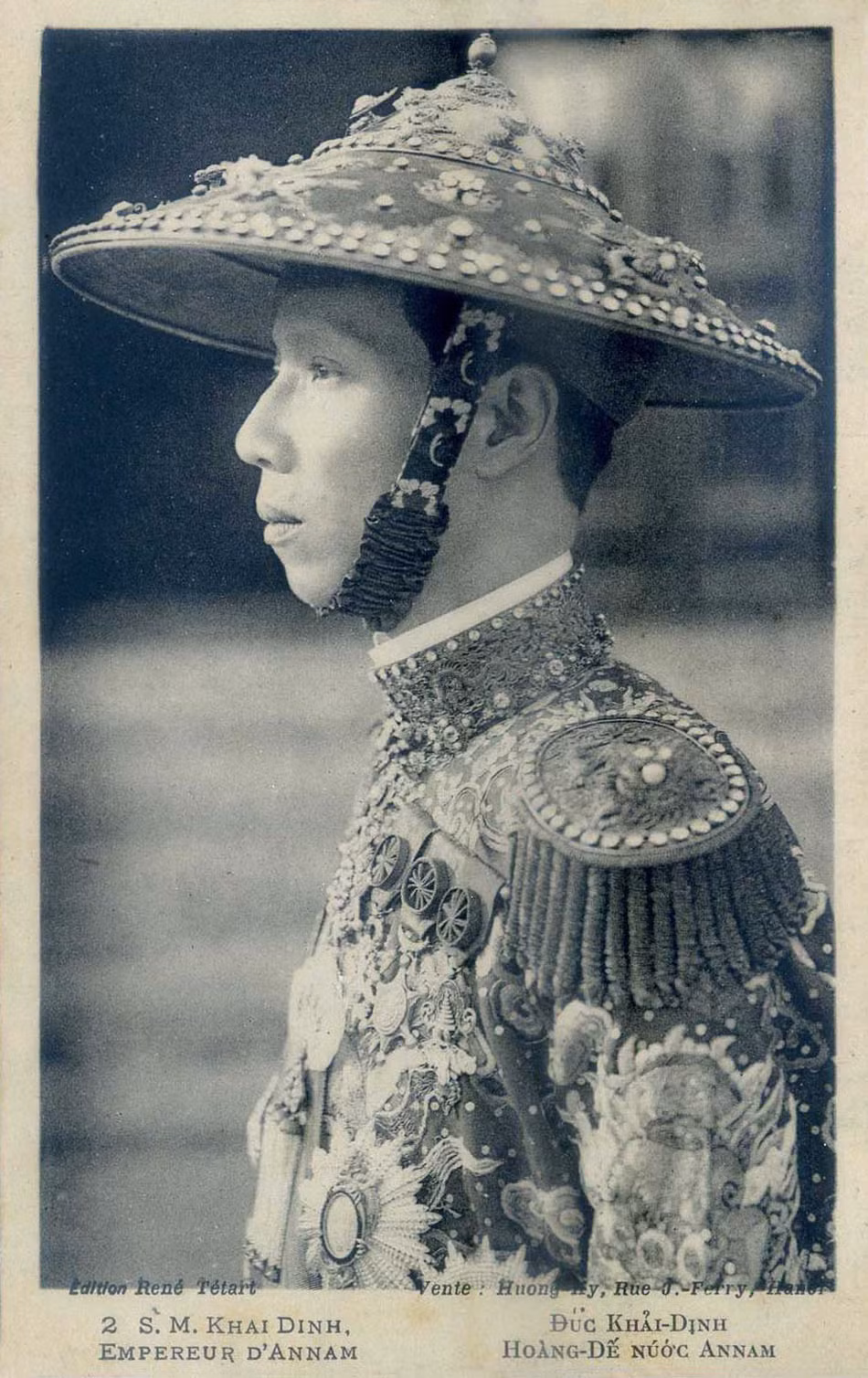 Thất điều trần viết: “Bệ hạ tự chế ra một thứ lễ phục kiểu mới, tự mặc ra để ra Triều. Kiểu ấy là trên áo cẩm bào cũ, thêu vào cái cầu vai kiểu Âu, còn cổ áo và tay áo thời đính vài ngọc lòe loẹt, Âu không ra Âu, Á không ra Á, lại trên nón vua thời thêu thêm những hình rồng phụng sáng ngời”.