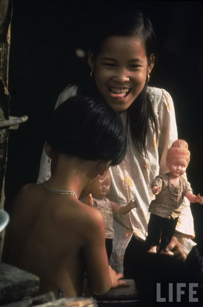 Tròn tỏ ra không sợ lính Mỹ. Trong tâm trí em lúc đó chỉ có hai nỗi lo, thứ nhất là không có tiền để trả cho “vé” đi máy bay, thứ hai là không thể đi về nhà với chiếc chân như vậy. Ảnh: Tròn và con búp bê được người Mỹ tặng khi ở trong bệnh viện.