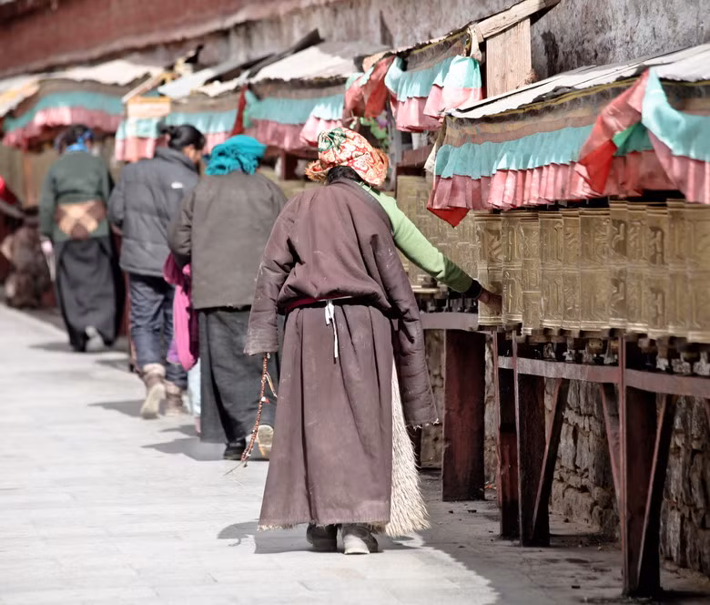 Ven tường bao ngoài dưới chân cung điện là Kora, một con đường với hàng trăm chiếc kinh luân (bánh xe Phật pháp) màu đồng in nổi câu kinh Om Mani Padme Hum xếp dọc theo tường. Những đoàn người Tạng vừa đi vừa đẩy kinh luân xoay theo chiều kim đồng hồ.