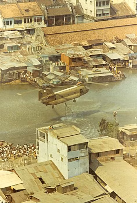 Chiếc trực thăng bay sát mặt nước để thả hai chiếc "xô" khổng lồ xuống nước...