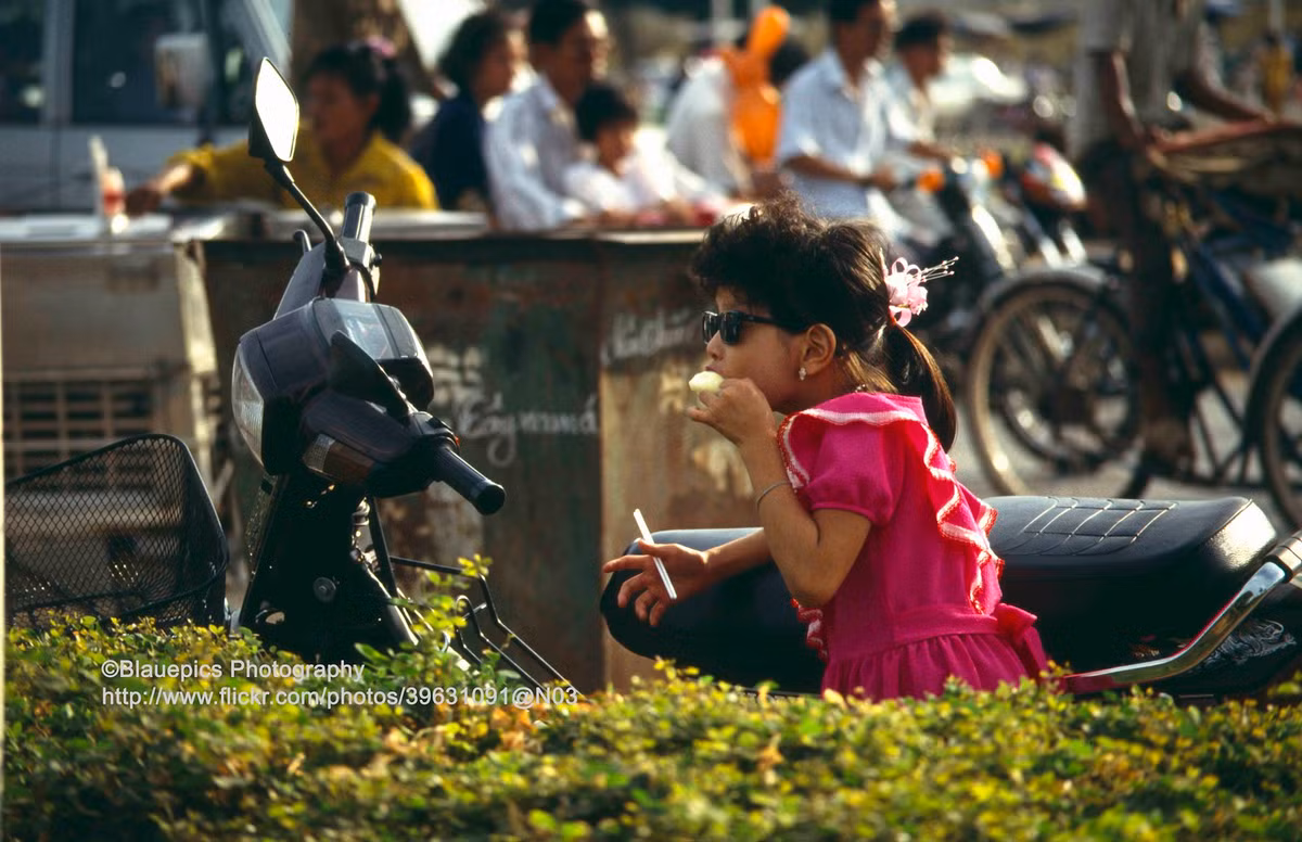 Bé gái ăn kem trên phố.