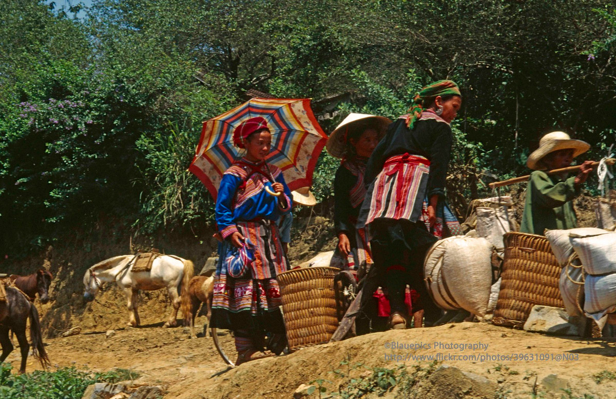 Đồng bào dân tộc H'Mông mang vác hàng hóa đến chợ phiên Bắc Hà, thị trấn Bắc Hà, Lào Cai năm 1998.
